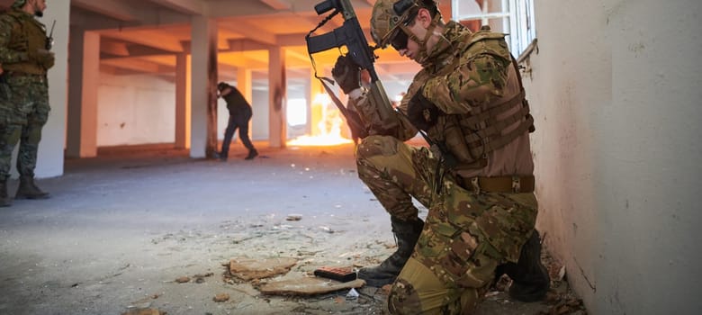 soldier in action near window changing magazine and take cover.