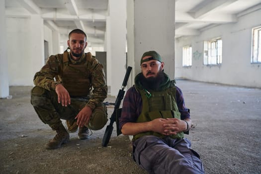 Group of soldiers discusses military tactics while situated in an abandoned building, meticulously planning their moves with focus and determination