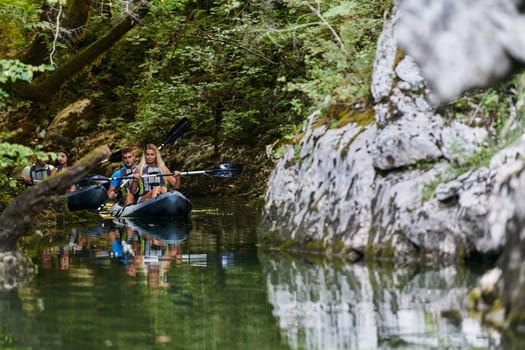 A young couple enjoying an idyllic kayak ride in the middle of a beautiful river surrounded by forest greenery.