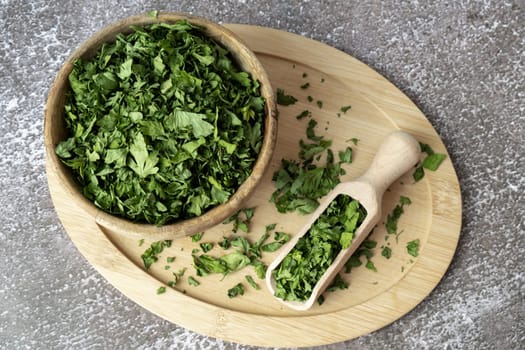 Wooden bowl with green dry parsley. Vegetarian bio organic salad herb healthy eating. Home garden immunity-boosting herbs. Seasonal harvest cottagecore