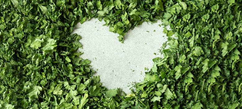 Background of green dry parsley in heart shape. Vegetarian bio organic salad lover herb healthy eating. Home garden immunity-boosting herbs. Seasonal harvest cottagecore