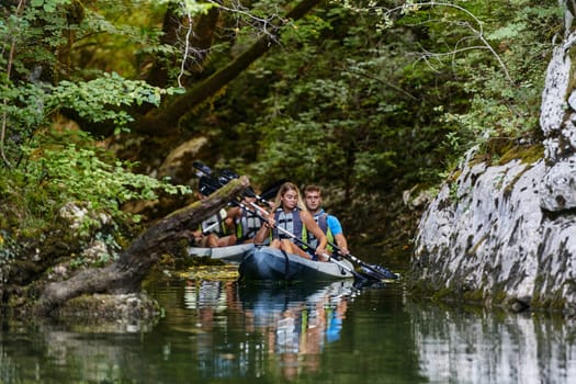 A group of friends enjoying having fun and kayaking while exploring the calm river, surrounding forest and large natural river canyons.