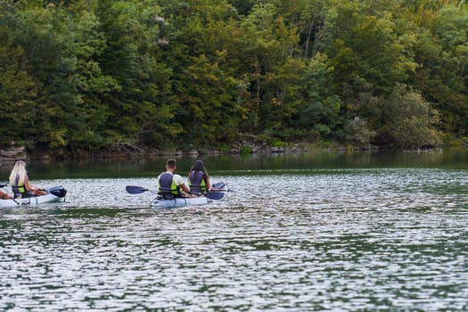 A young couple enjoying an idyllic kayak ride in the middle of a beautiful river surrounded by forest greenery.