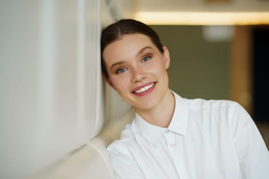 Portrait of a beauty young woman in elegant clothes posing smiling leaning on a cafeteria