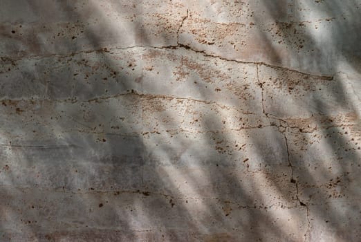 The sun is shining through the old brick cracked wall. This causes light and shadow reflecting on the wall. The surface of the wall is rough and the color is uneven, Space for text, Selective focus.