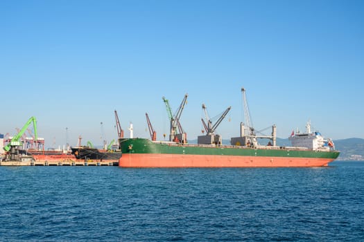 Loading onto bulk carrier ship at commercial port on a sunny day