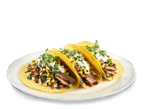 Ancho Chile Pork Tacos with roasted corn salsa and lime crema served on a transparent. Food isolated on transparent background.