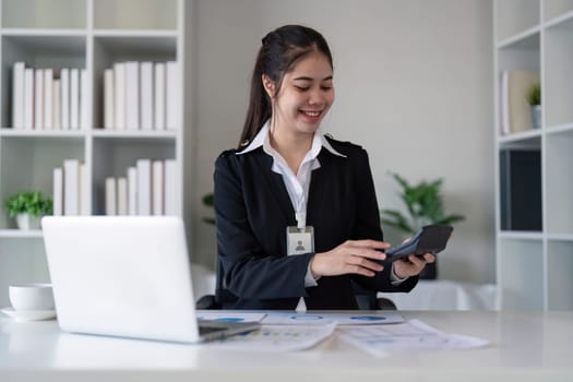 Businesswoman using calculator in office. Concept of finance, technology, and productivity.