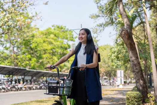 Businesswoman commuting to work by bicycle in urban park. Concept of eco friendly transportation, active lifestyle, and outdoor exercise.