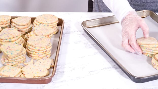 The sugar cookies, filled with sprinkles mixed into the dough, are carefully arranged with meticulous precision into a rustic brown paper box.