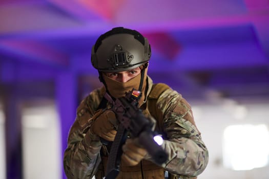 A professional soldier undertakes a perilous mission in an abandoned building illuminated by neon blue and purple lights.