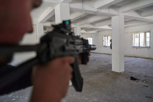 In an abandoned building, a terrorist takes aim with a rifle at a military opponent, engaged in a fierce battle for territorial control, embodying the dangers and tensions of the conflict