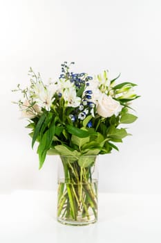 A stunning bouquet featuring fresh white roses and assorted flowers gracefully arranged in a vase, exuding timeless beauty.