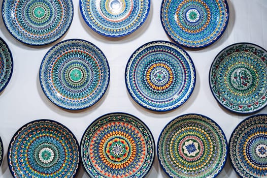 Uzbek handmade ceramic plates with hand-painted ethnic Oriental colorful patterns in tableware store in Uzbekistan