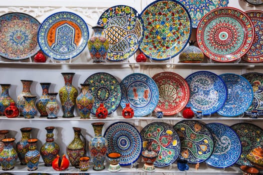 Uzbek ceramic plates, dishes and vases with hand-painted traditional ethnic colorful patterns in tableware store in Uzbekistan in Tashkent