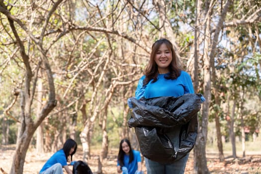 Female volunteer cleaning forest. Concept of teamwork, environment, and community service.