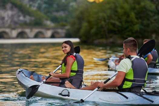 A group of friends enjoying having fun and kayaking while exploring the calm river, surrounding forest and large natural river canyons.