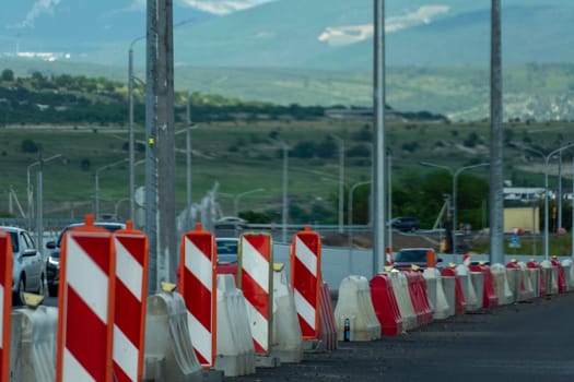 Red, white plastic safety barriers along road. Ensuring road safety with visible barriers. Effective safety measures for roadside work