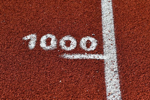 One thousand meter mark on a running track at a stadium