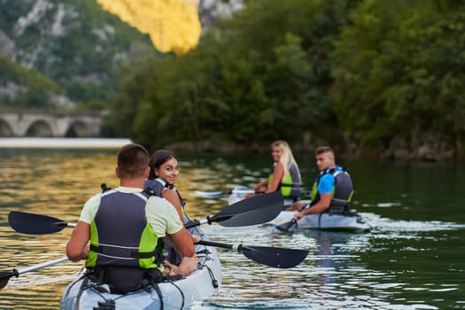 A group of friends enjoying having fun and kayaking while exploring the calm river, surrounding forest and large natural river canyons.