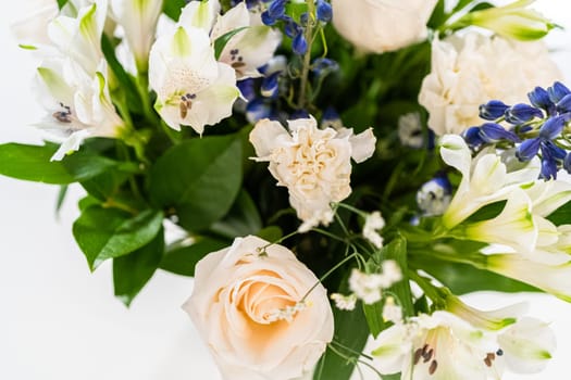 A stunning bouquet featuring fresh white roses and assorted flowers gracefully arranged in a vase, exuding timeless beauty.