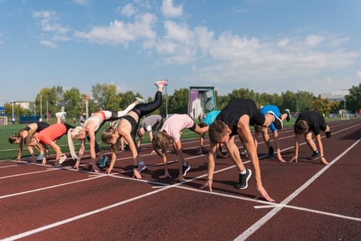 Group of young athlete runnner are training at the stadium outdoors