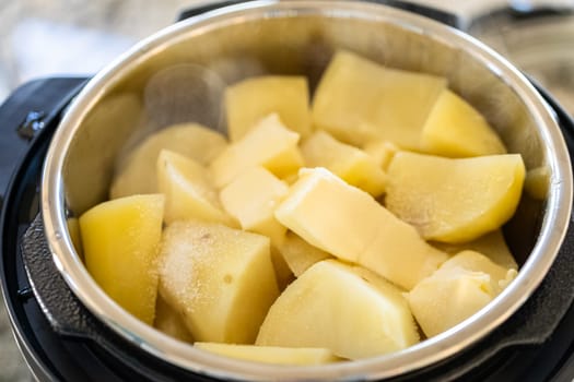 In a sleek modern kitchen, preparing velvety mashed potatoes using a pressure cooker for a quick and delicious meal.