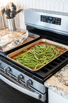 Watch as fresh green beans are beautifully roasted to perfection on a baking sheet with a silicone mat, adding a burst of flavor to your meal.