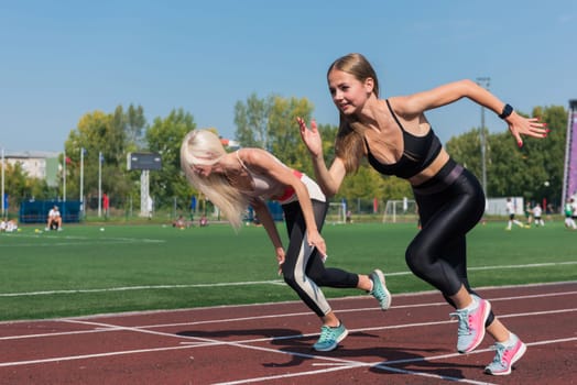 Two athlete young woman runnner are training at the stadium outdoors