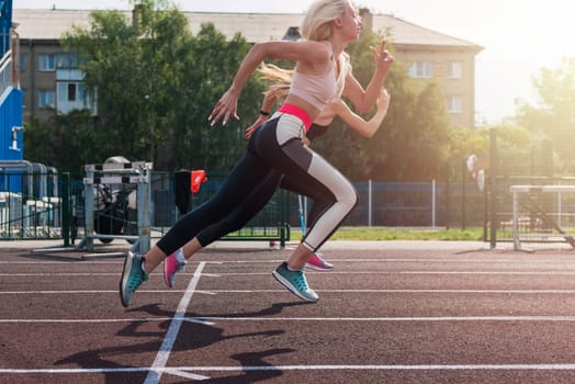 Two athlete young woman runnner are training at the stadium outdoors