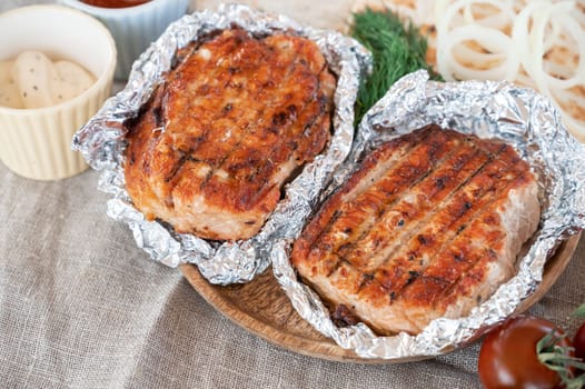 Grilled pork meat in foil with flapjack and vegetables. Summer rest concept