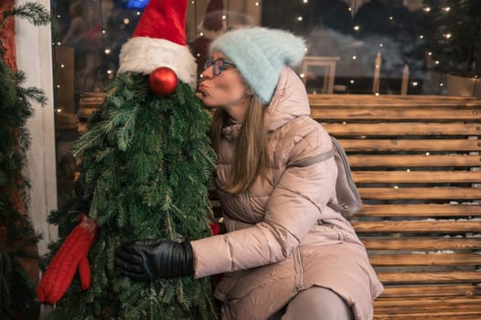 Pretty woman with fir tree decorated mannequin. Xmas holidays, New Year or Christmas concept