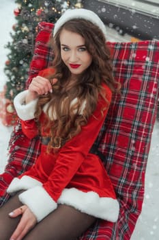 Young woman in santa costume resting at winter campsite. New year celebration concept