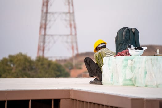 labourer with face covered to protect from the heat looking down showing the real estate industry in India