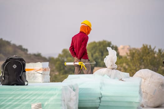 labourer with face covered to protect from the heat looking down showing the real estate industry in India