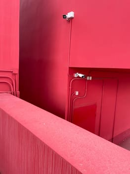 video cameras on the wall of the red building