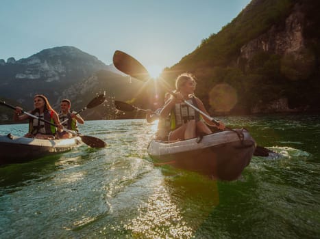 A group of friends enjoying fun and kayaking exploring the calm river, surrounding forest and large natural river canyons during an idyllic sunset