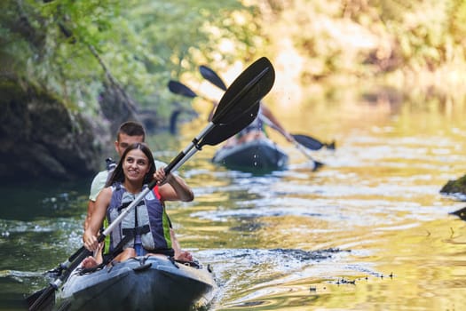 A group of friends enjoying having fun and kayaking while exploring the calm river, surrounding forest and large natural river canyons.