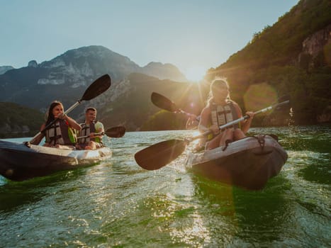 A group of friends enjoying fun and kayaking exploring the calm river, surrounding forest and large natural river canyons during an idyllic sunset