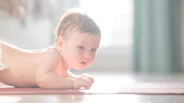 Cute little boy lying on his forearms on the floor