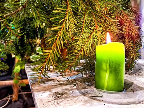 Candle burning amidst holiday decorations. Festive Candles Lighting Up Christmas-Adorned Room at Night