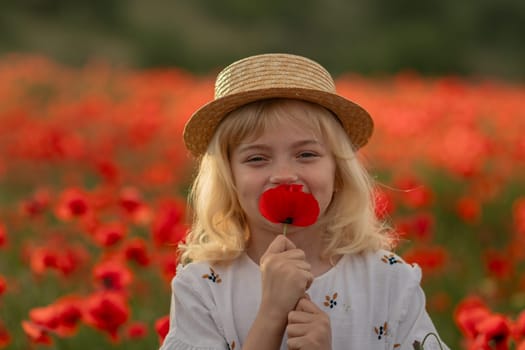 A young girl is standing in a field of red flowers, holding a red flower in her hand