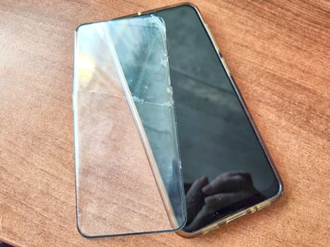 Removing Protective Film From Cracked Screen. Peeling off a cracked screen protector from a phone