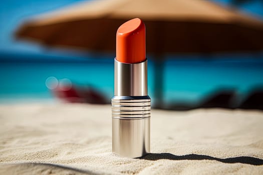 A small red lipstick is sitting on the sand next to a beach umbrella. The scene is peaceful and relaxing, with the sun shining down on the beach and the sound of waves in the background