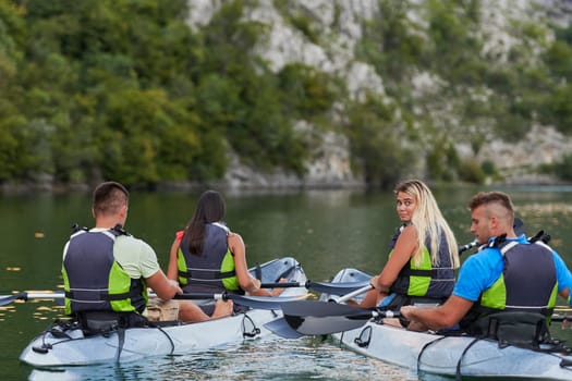 A group of friends enjoying having fun and kayaking while exploring the calm river, surrounding forest and large natural river canyons.