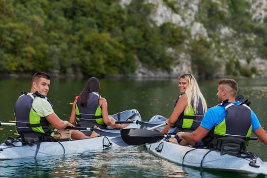 A group of friends enjoying having fun and kayaking while exploring the calm river, surrounding forest and large natural river canyons.