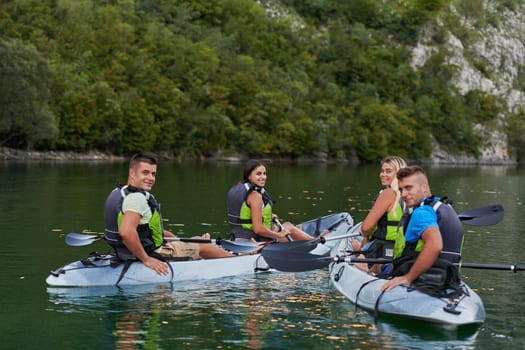 A group of friends enjoying having fun and kayaking while exploring the calm river, surrounding forest and large natural river canyons.