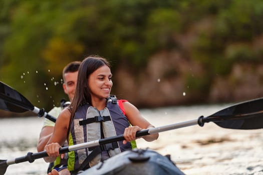 A young couple enjoying an idyllic kayak ride in the middle of a beautiful river surrounded by forest greenery.