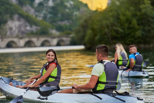 A group of friends enjoying having fun and kayaking while exploring the calm river, surrounding forest and large natural river canyons.