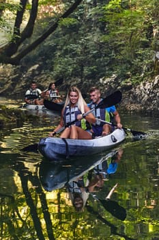 A group of friends enjoying having fun and kayaking while exploring the calm river, surrounding forest and large natural river canyons.